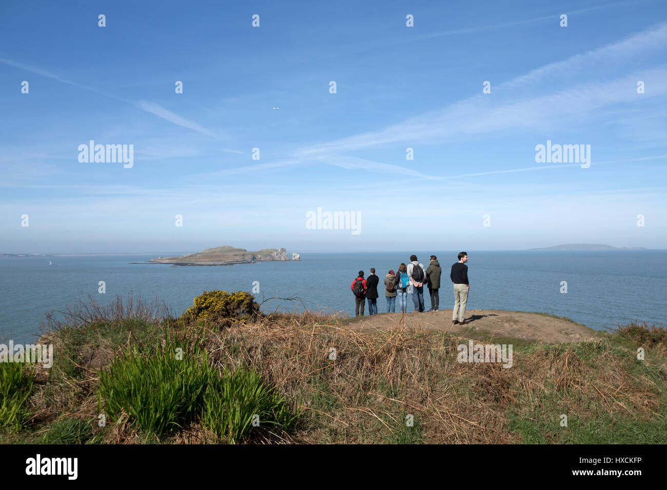 Un grupo de turistas mirando a lo largo de la bahía de Dublín, desde Howth, Dublín, Irlanda. Foto de stock