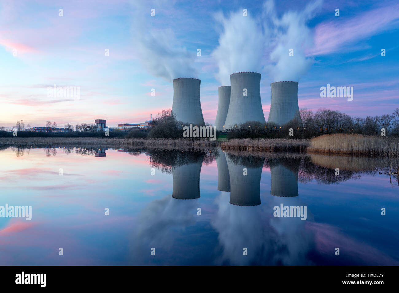 Las plantas de energía nuclear después del atardecer. Atardecer paisaje con grandes chimeneas. Foto de stock