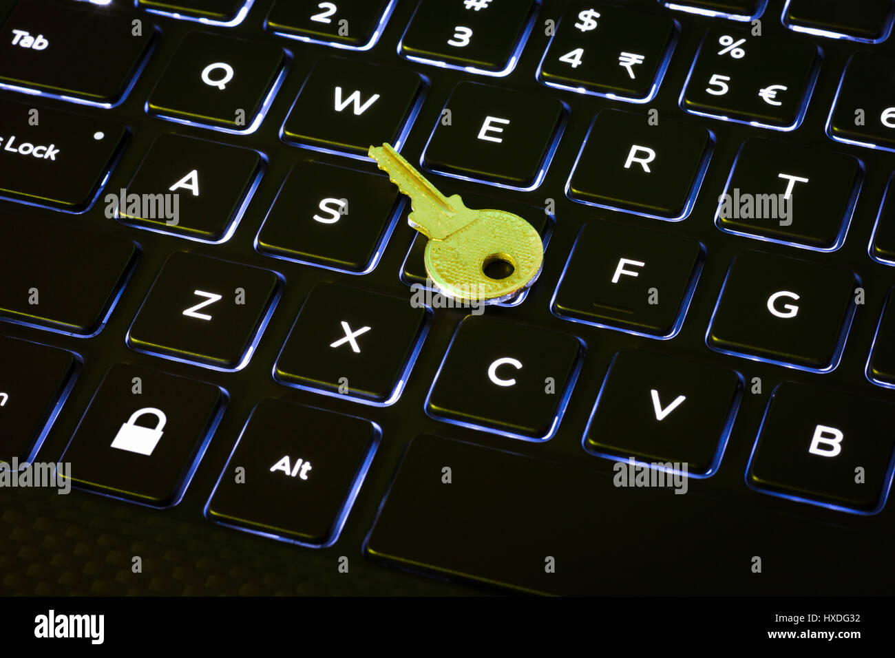 La llave y el botón de bloqueo en un teclado de ordenador retroiluminado Foto de stock
