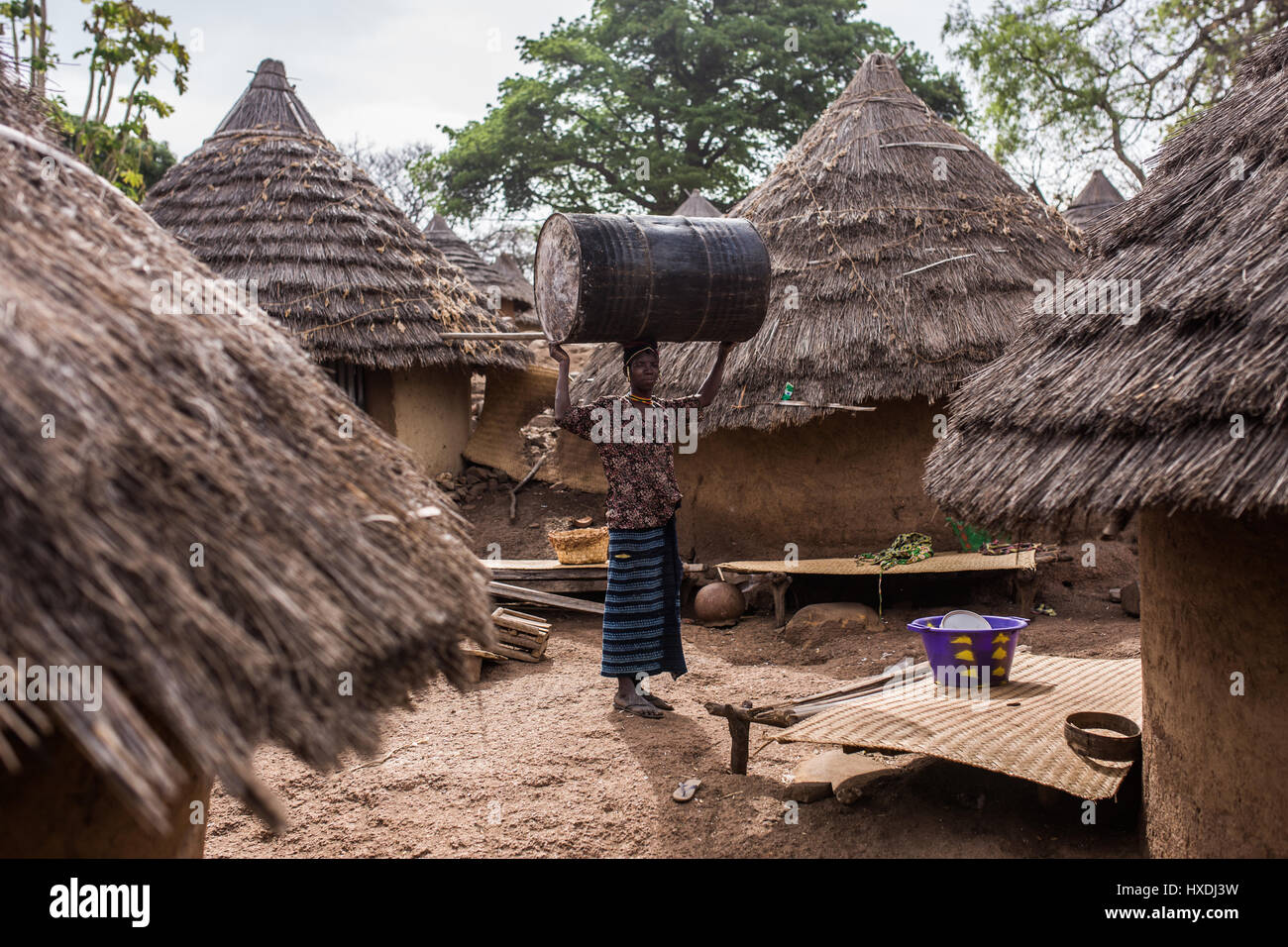Mujer en una remota aldea bedick está llevando un barril de acero sobre su cabeza Foto de stock