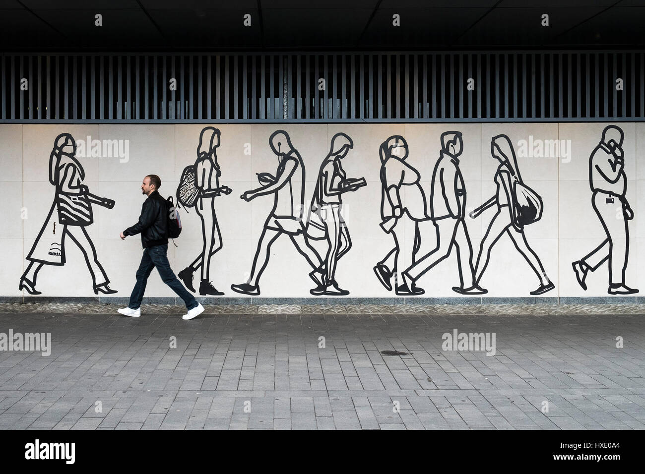 Paseos peatonales pasado un mural obra de arte público cifras pared Londres Foto de stock