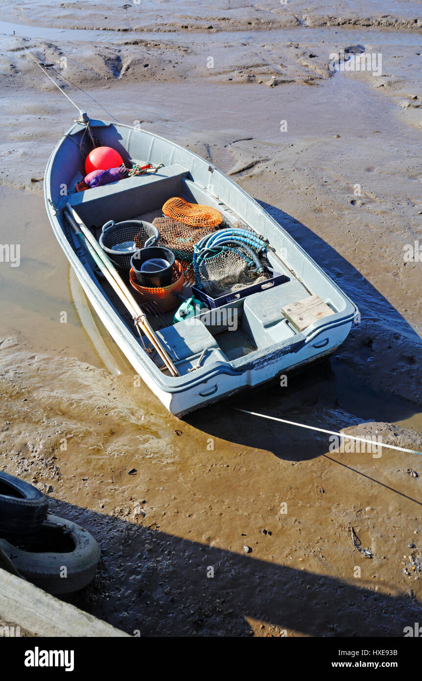 Pequeño barco pesquero con equipo varado en la marea baja en el norte de la costa de Norfolk en Brancaster Staithe, Norfolk, Inglaterra, Reino Unido. Foto de stock