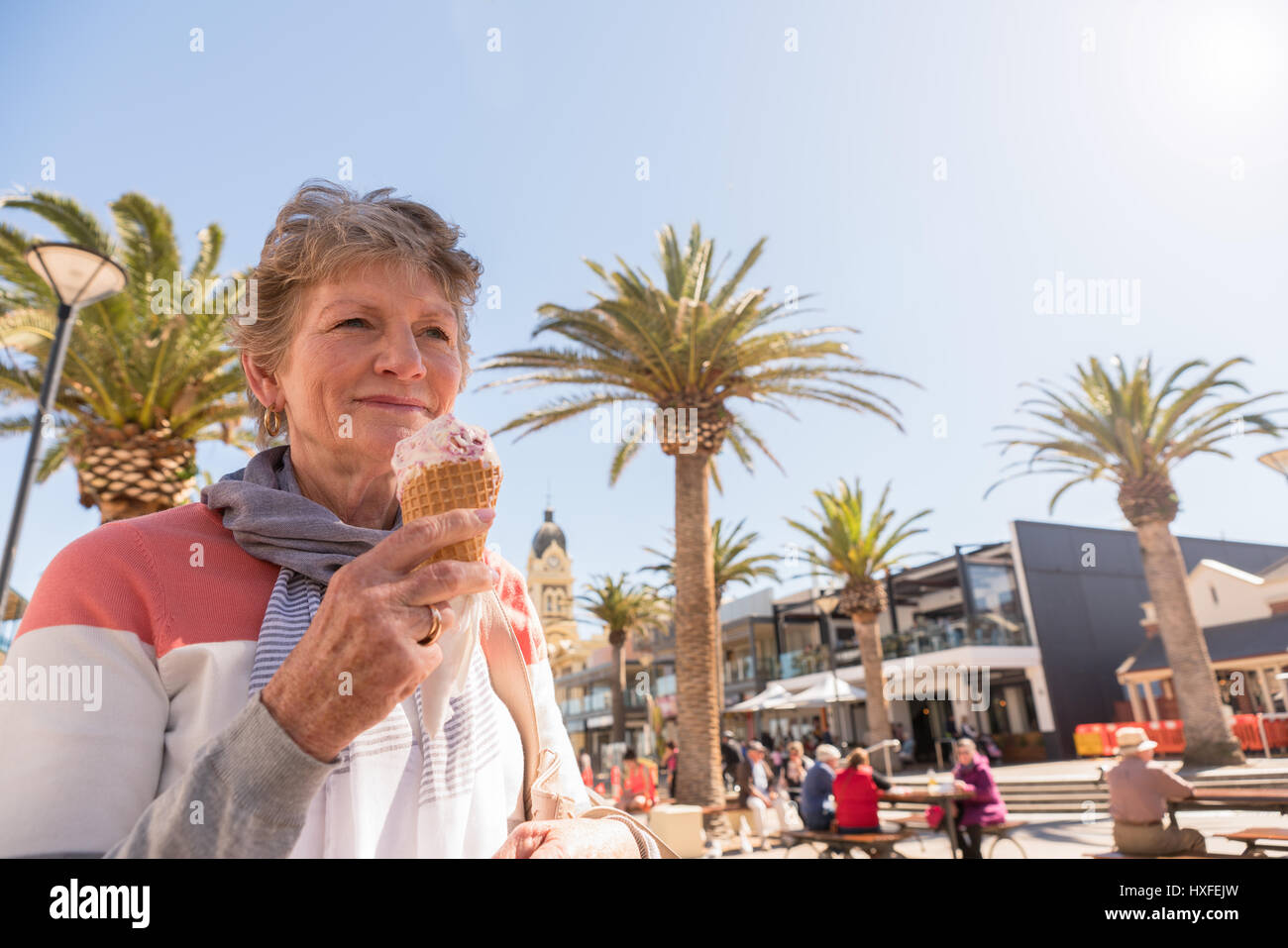 Feliz sonriente dama comer helado en el Beachside Glenelg, Adelaide, Australia del Sur Foto de stock