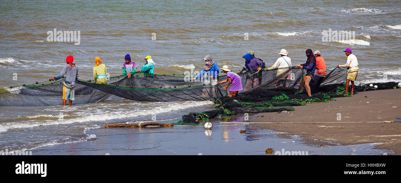 Los miembros de una aldea de pescadores filipinos lance en su seine net en Baybay Beach, Roxas City, Capiz, Isla de Panay, Filipinas Foto de stock
