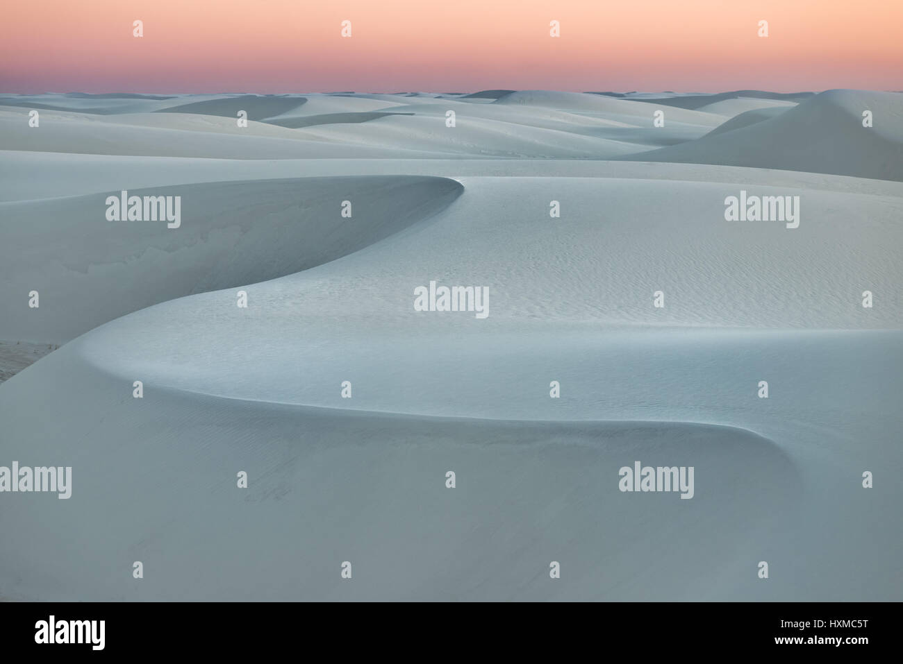 Las dunas de arena al atardecer con cielo anaranjado, Monumento Nacional White Sands, Nuevo México Foto de stock