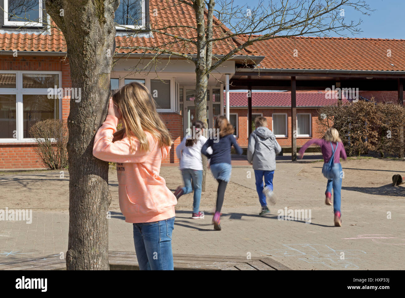 Los niños en la escuela primaria jugando al escondite durante el rodaje Foto de stock