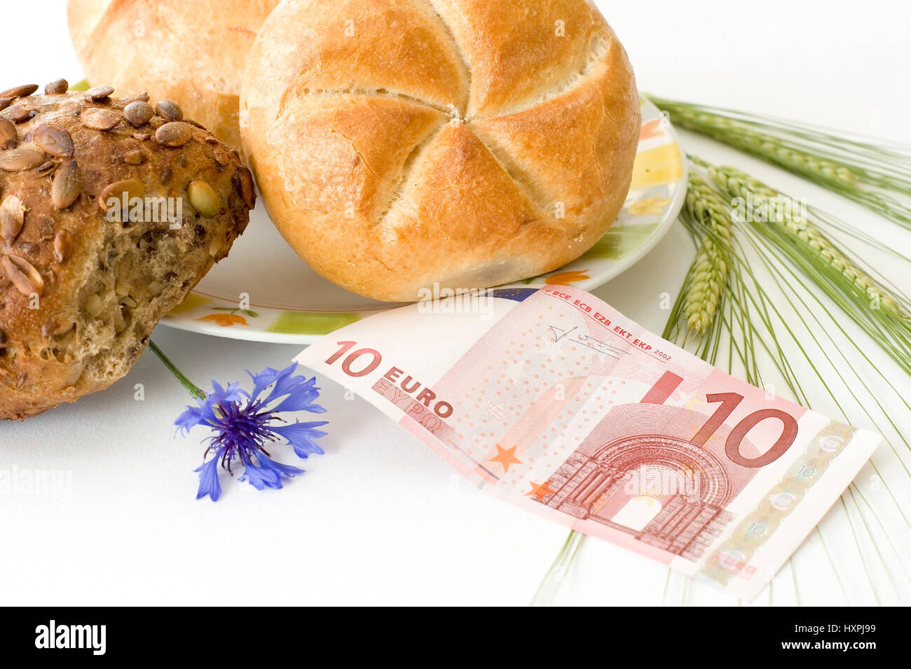 Los bollos de pan con diez euronotes y grano, mit Brötchen zehn Euroschein und Getreide Foto de stock