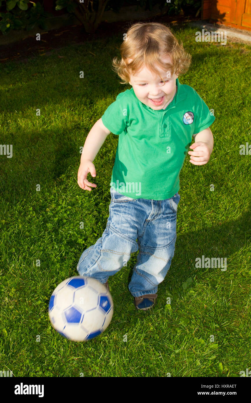Niño juega fútbol, tipo spielt Fußball Foto de stock