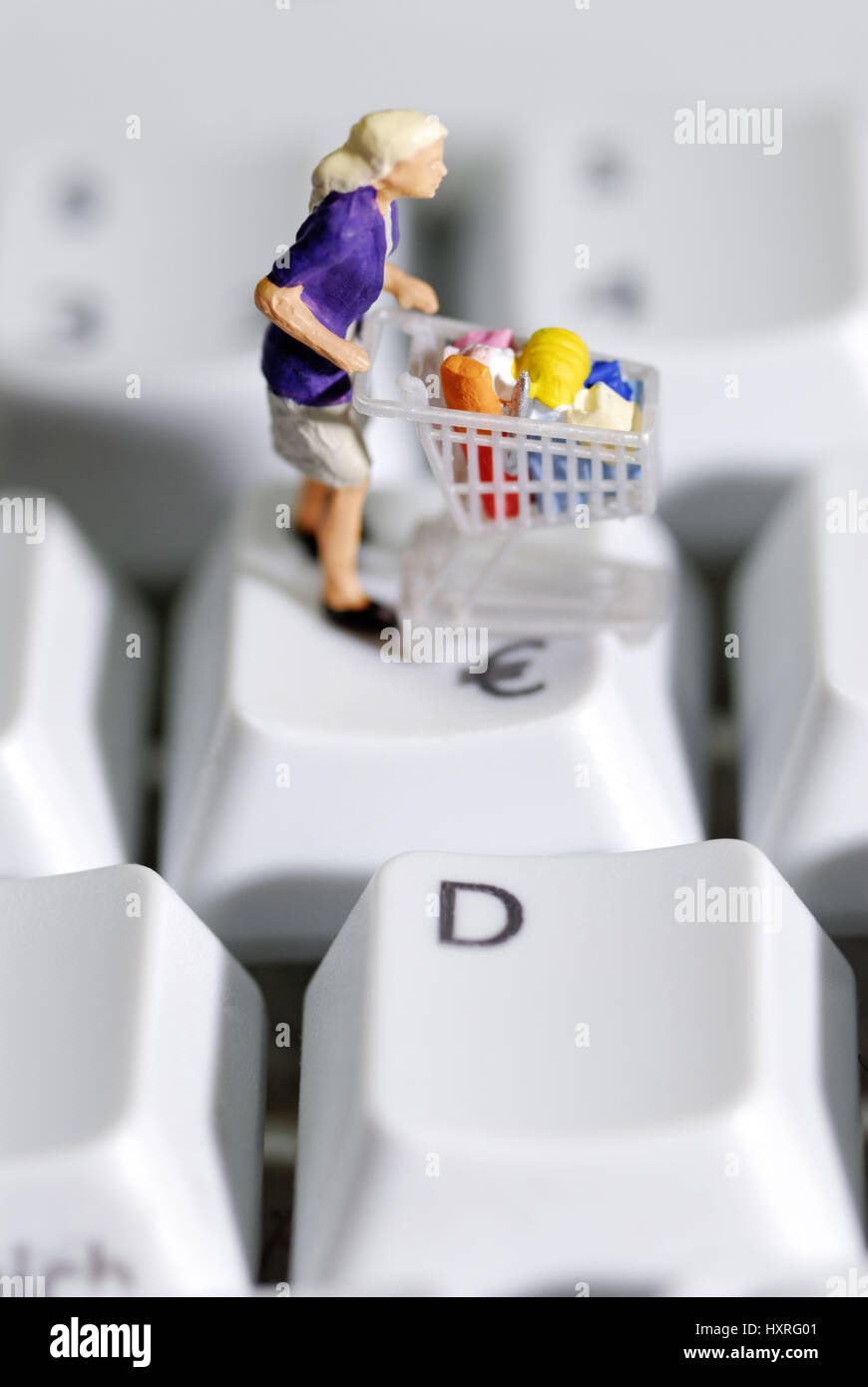 Mujer por compras en el teclado del ordenador, las compras en línea, Frau mit Einkaufswagen auf Computertastatur, Online-Shopping Foto de stock