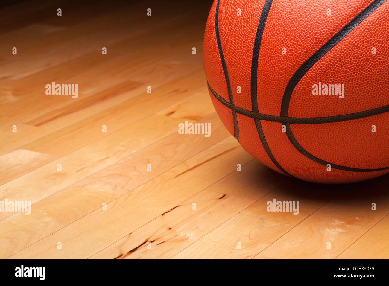 Primer plano de una pelota de baloncesto en un gimnasio de piso de madera Foto de stock