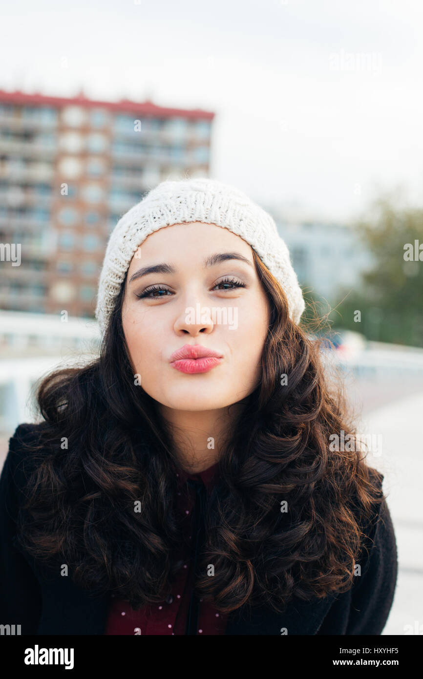 Urban chica con gorro de lana besar a la cámara en la ciudad Fotografía de  stock - Alamy