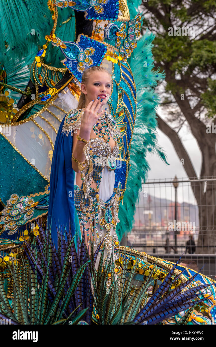 Una mujer con un disfraz de carnaval con un tocado de plumas azul