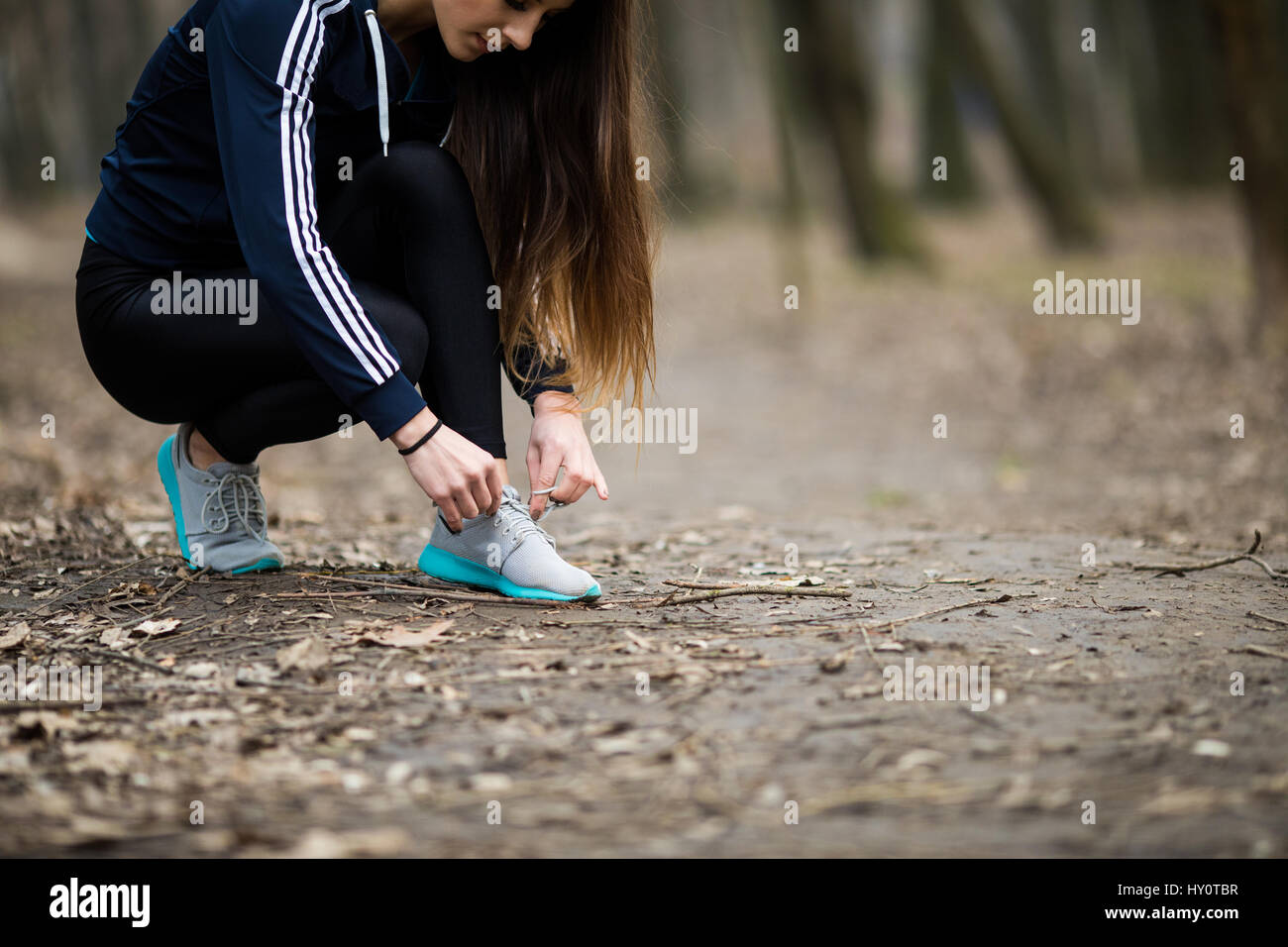 Mujer joven atar los cordones de los zapatos para correr antes de entrenar  Fotografía de stock - Alamy