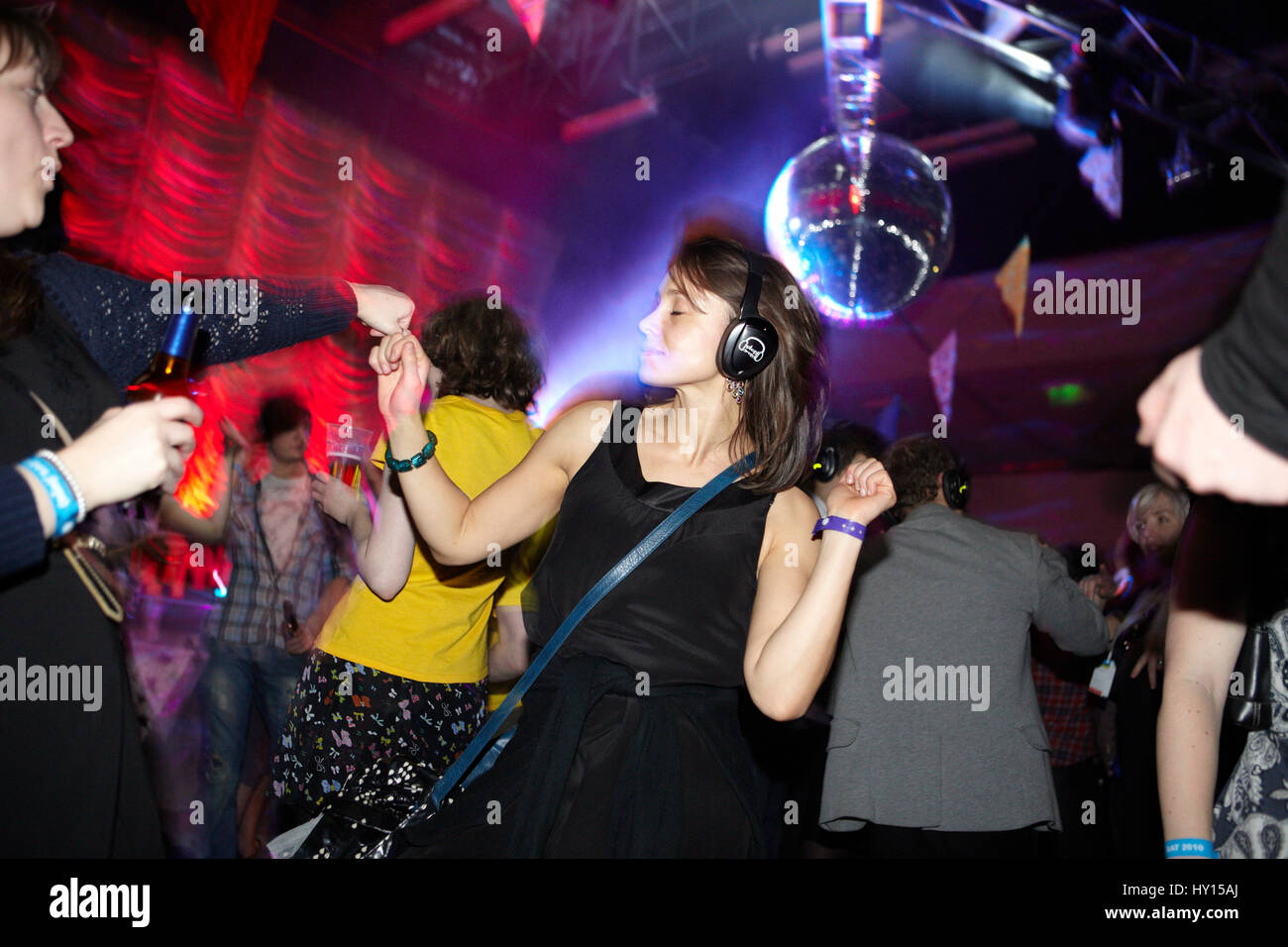 Mujer en un vestido negro bailando en una discoteca silenciosa, SWN festival, Cardiff Foto de stock