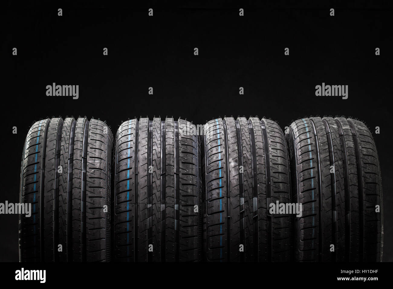 Pila de flamante coche neumáticos de alto rendimiento en la limpieza del  bajo fondo negro clave studio Fotografía de stock - Alamy