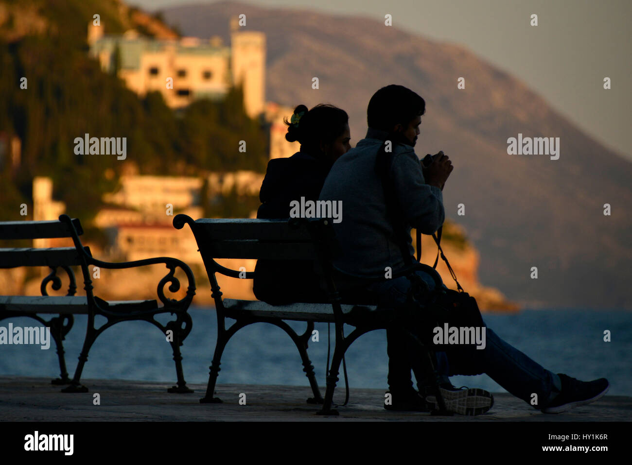 Siluetas de par en la banqueta, con vistas del puerto. Dubrovnik, Croacia. Foto de stock