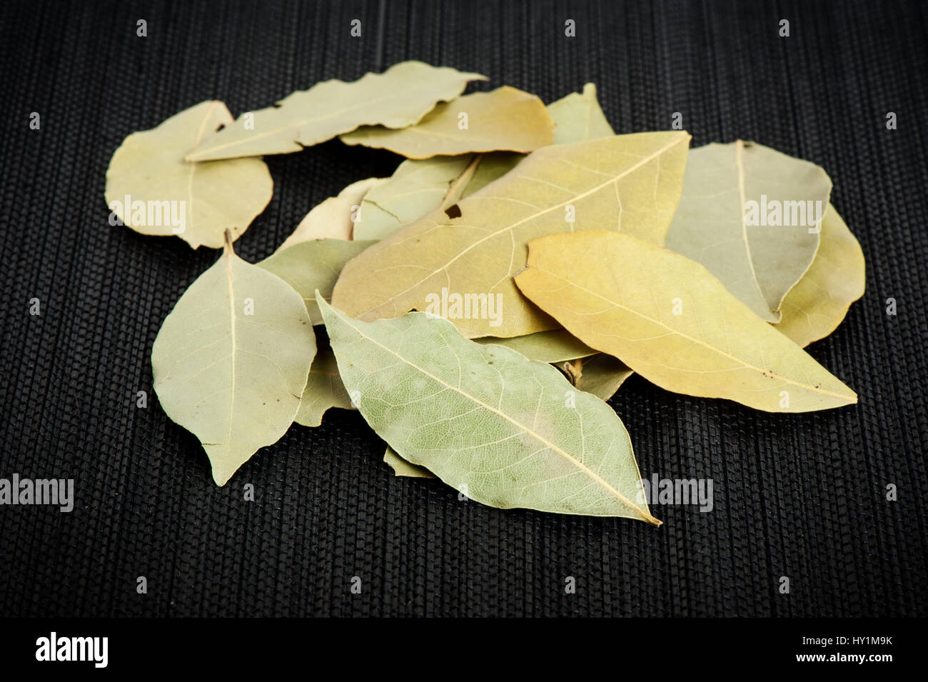 Hojas de laurel seco sobre fondo negro, hierbas fragantes Fotografía de