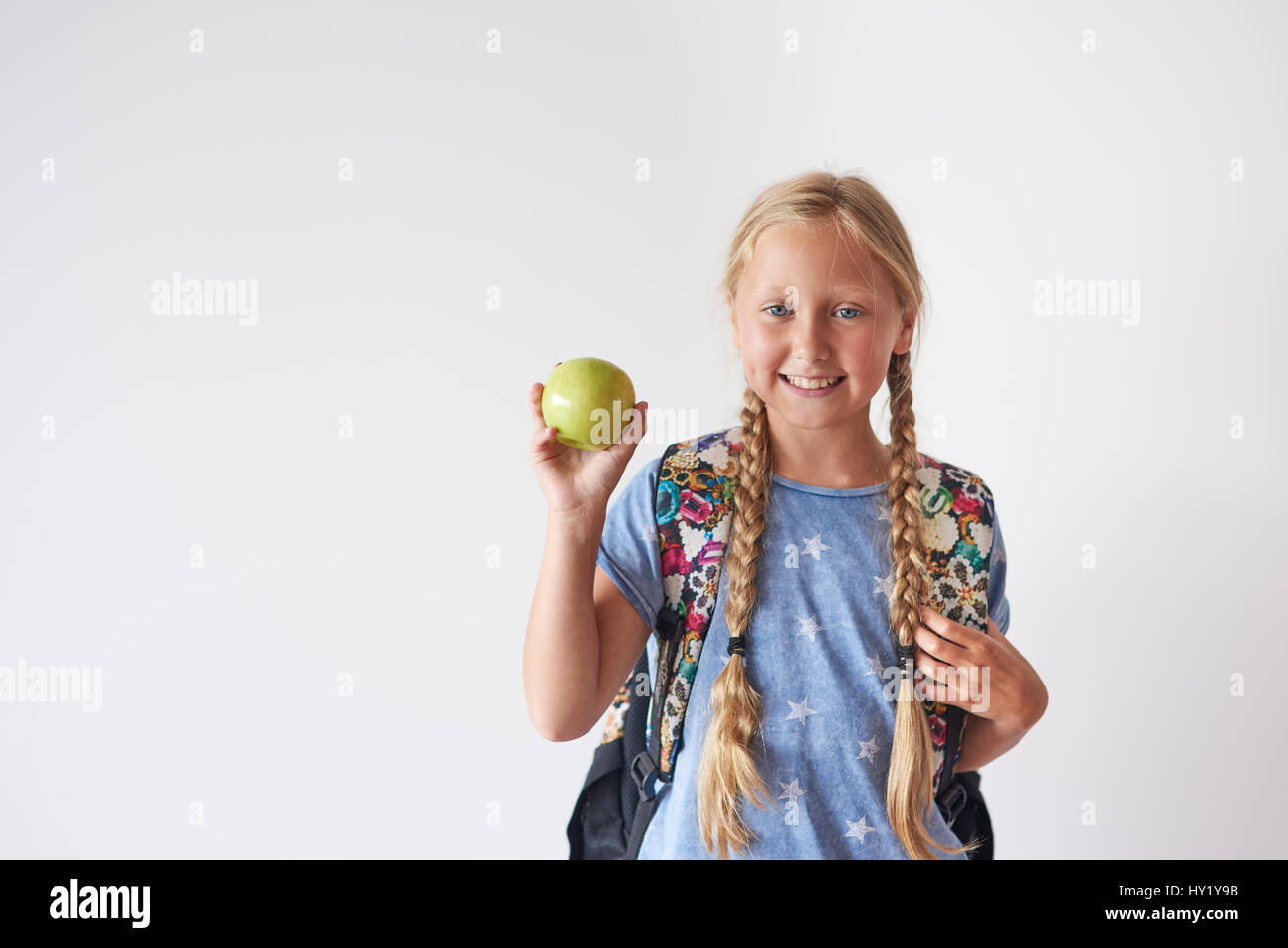 Cintura para arriba del estudiante Chica sujetando una manzana Foto de stock