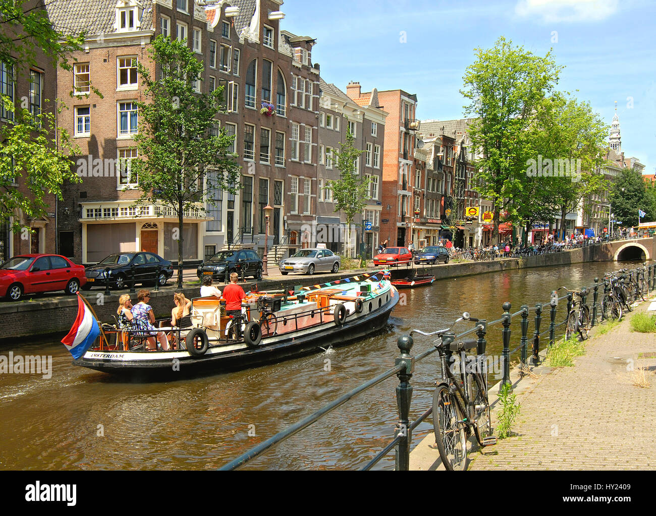 Imagen de house boat conduciendo en un canal de agua en el interior de la ciudad de Amsterdam, Holanda. Foto de stock