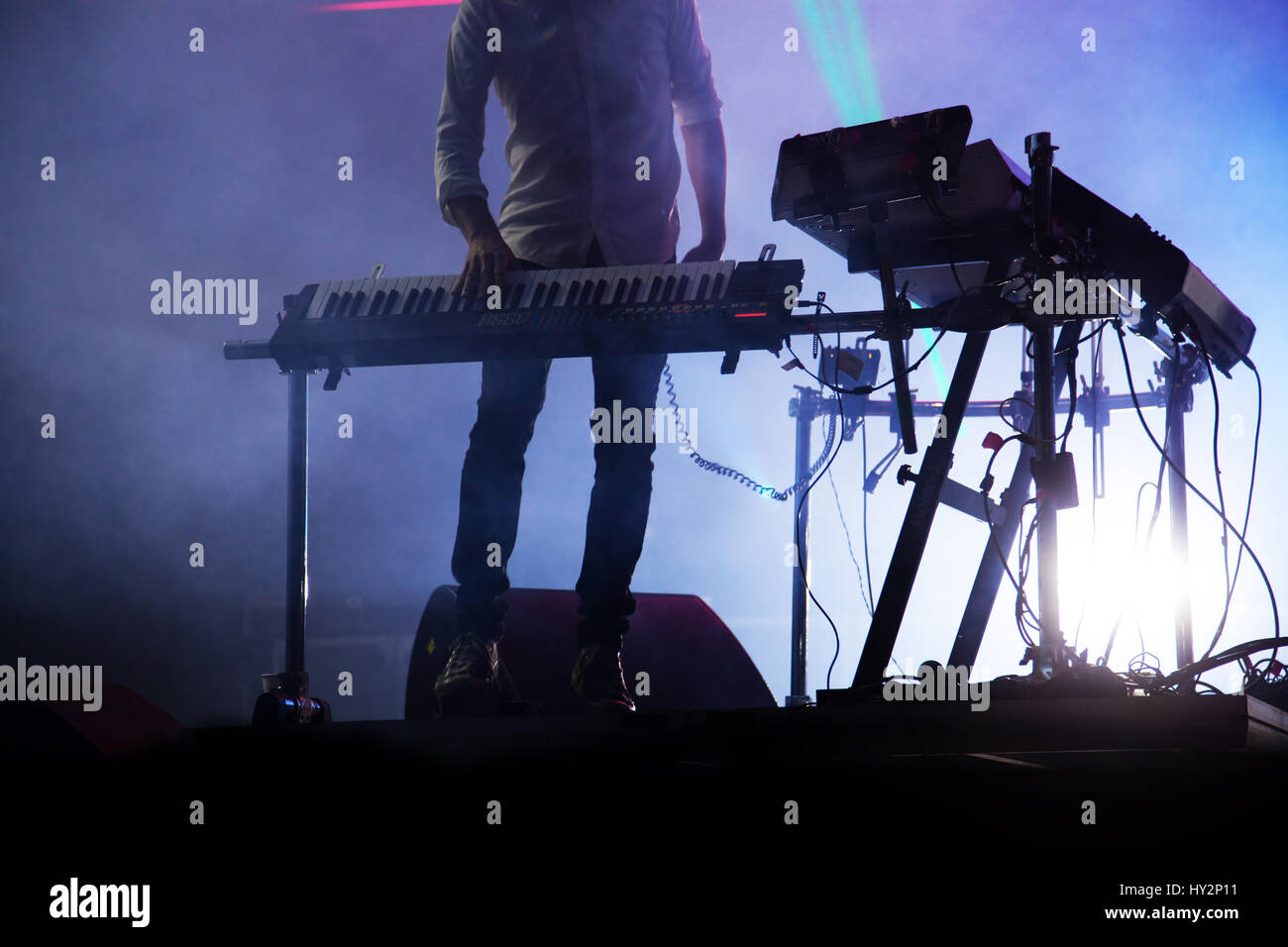 Disco jokey mezclar en el escenario más iluminada de fondo de humo Foto de stock