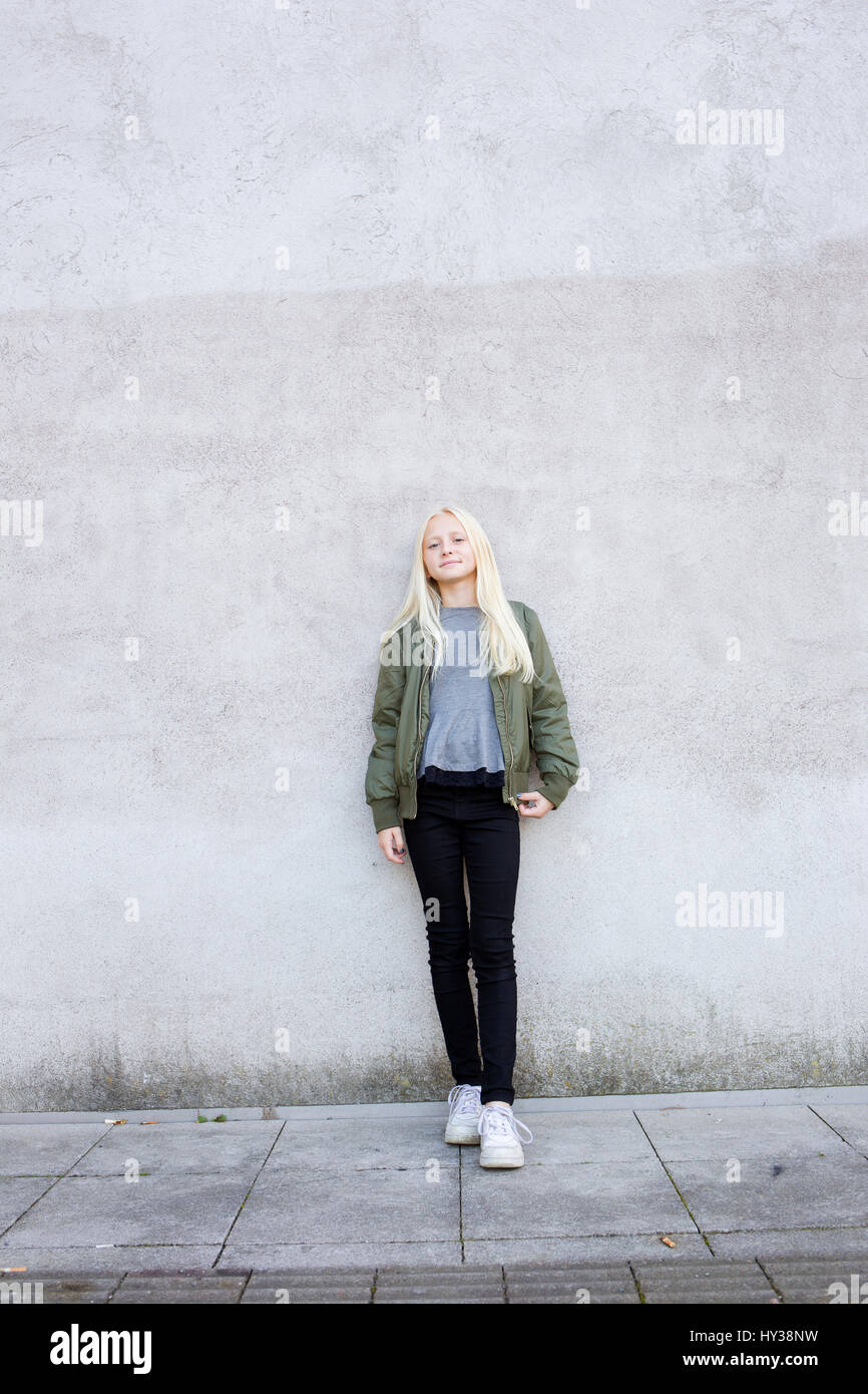 Suecia, Retrato de niña (12-13) de pie contra la pared de hormigón Foto de stock