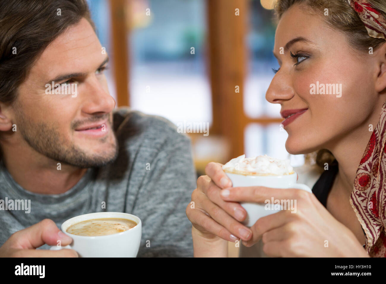 Cerca de la romántica pareja joven con café en la cafetería Foto de stock