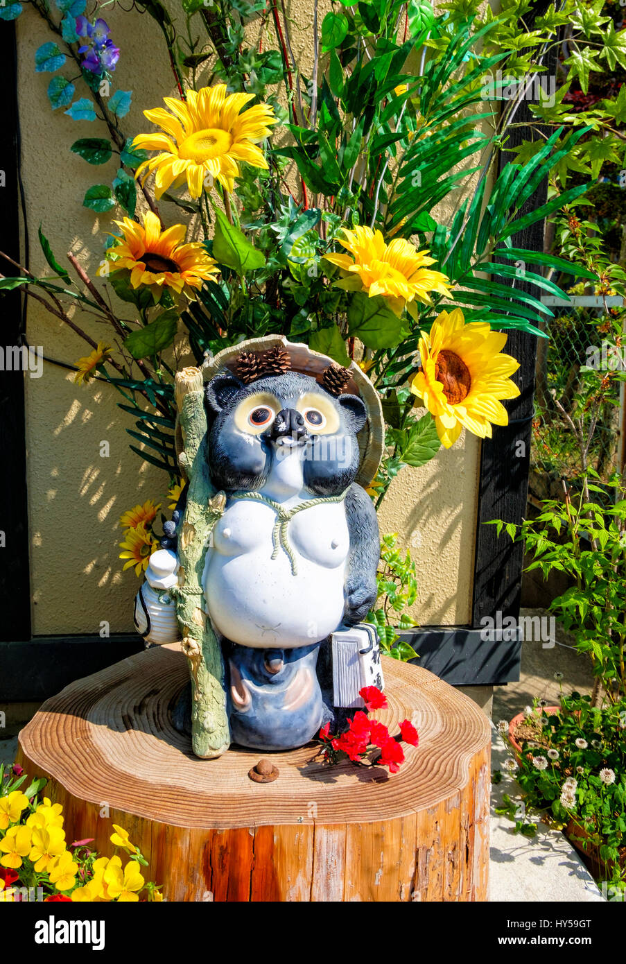 Tanuki estatuas son ornamentos de jardín común en Japón. Tanuki, o japonés racoon perros mapaches (independientes o perros) son comunes en el folclore japonés. Foto de stock