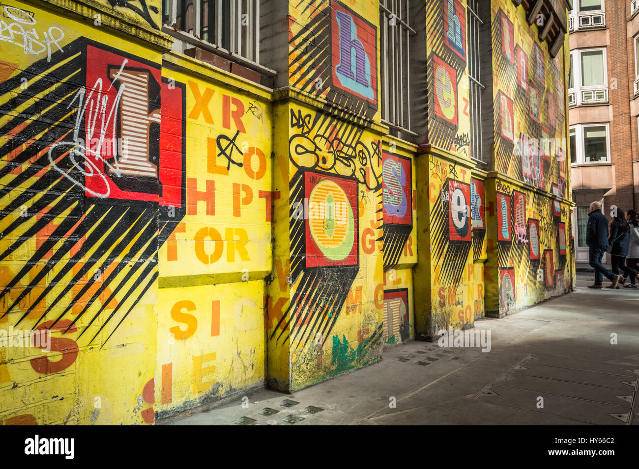 Casa de "Alfabeto", arte de la calle por artista, Ben Eine - colorido las letras del alfabeto en una pared amarilla en Spitalfields, East London Foto de stock