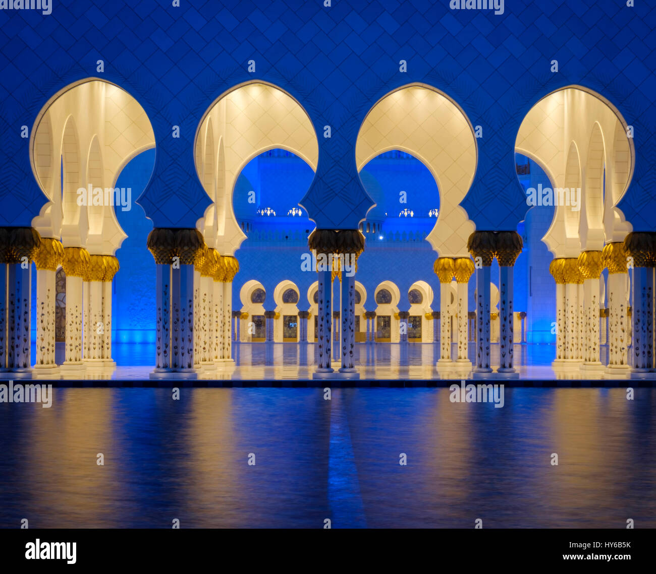 Los Emiratos Árabes Unidos, ABU DHABI - CIRCA ENERO DE 2017: piscina, arcos y columnas de la mezquita de Sheikh Zayed en la noche. Foto de stock