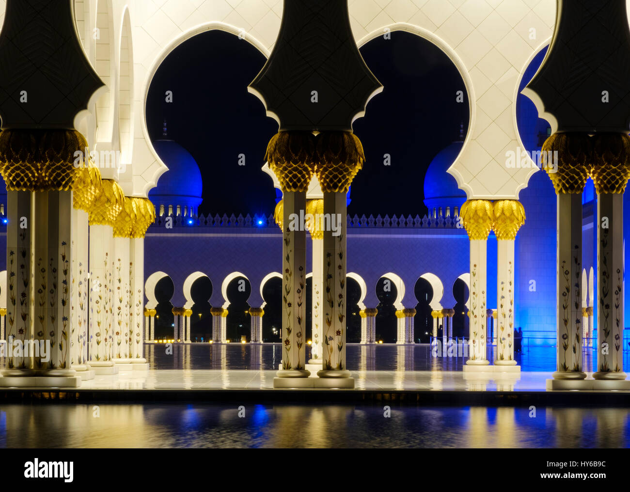 Los Emiratos Árabes Unidos, ABU DHABI - CIRCA ENERO DE 2017: piscina, arcos y columnas de la mezquita de Sheikh Zayed en la noche. Foto de stock