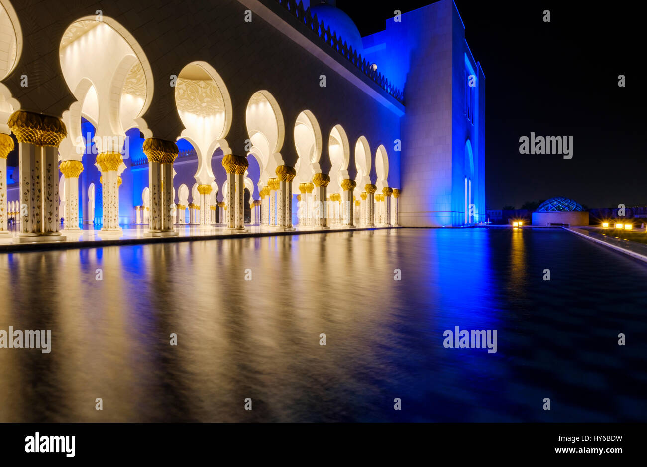 Los Emiratos Árabes Unidos, ABU DHABI - CIRCA ENERO DE 2017: piscina, arcos y columnas de la mezquita de Sheikh Zayed en la noche. Foto de stock