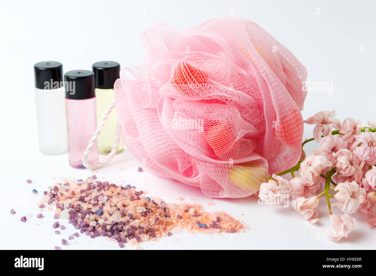 Esponja de baño y sal con flores rosas y aceites esenciales Foto de stock