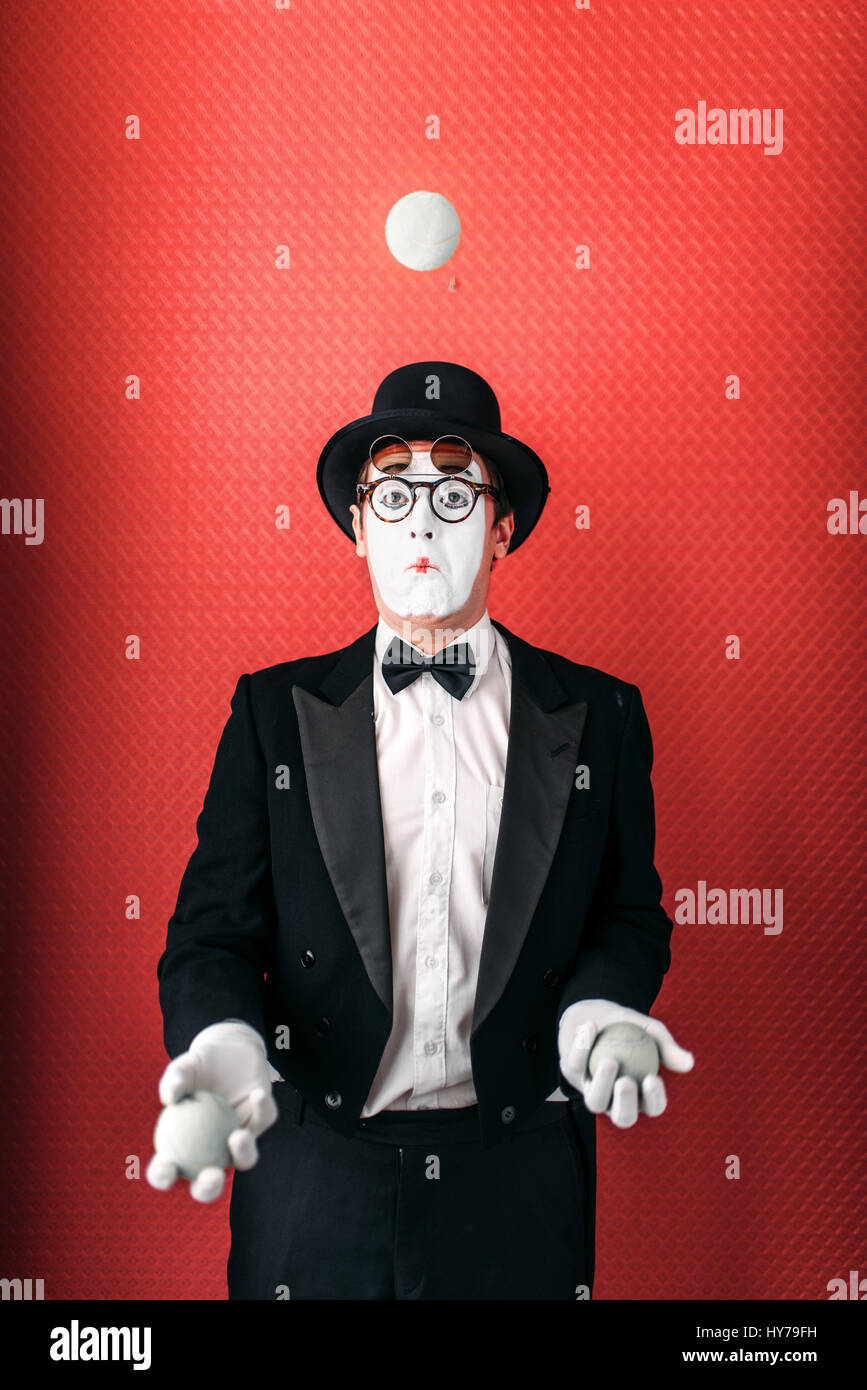 La pantomima masculina malabares con bolas. Comedia artista mime en traje,  guantes, gafas, maquillaje, máscara y sombrero. Malabarista de circo  Fotografía de stock - Alamy