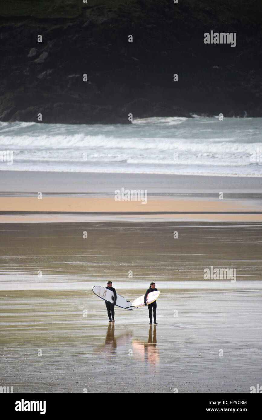 Los surfistas Caminando Costa Playa mar olas de Surf costa escarpada costa Fistral Cornwall Foto de stock