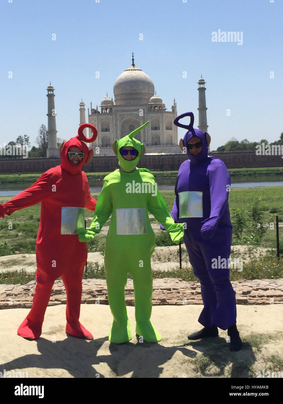 Juan Newman (izquierda) Tyler Newman (oriente) y Phillip Miller (derecha)  vestida como Teletubbies fuera del Taj Mahal. Tres británicos están  diciendo E-OH al subcontinente por asumir el reto de la excéntrica cruzando