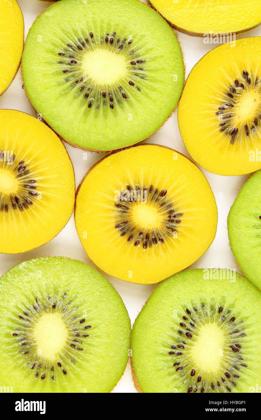 Rebanadas de frescas frutas kiwi verde y amarillo en los alimentos como textura de fondo Foto de stock