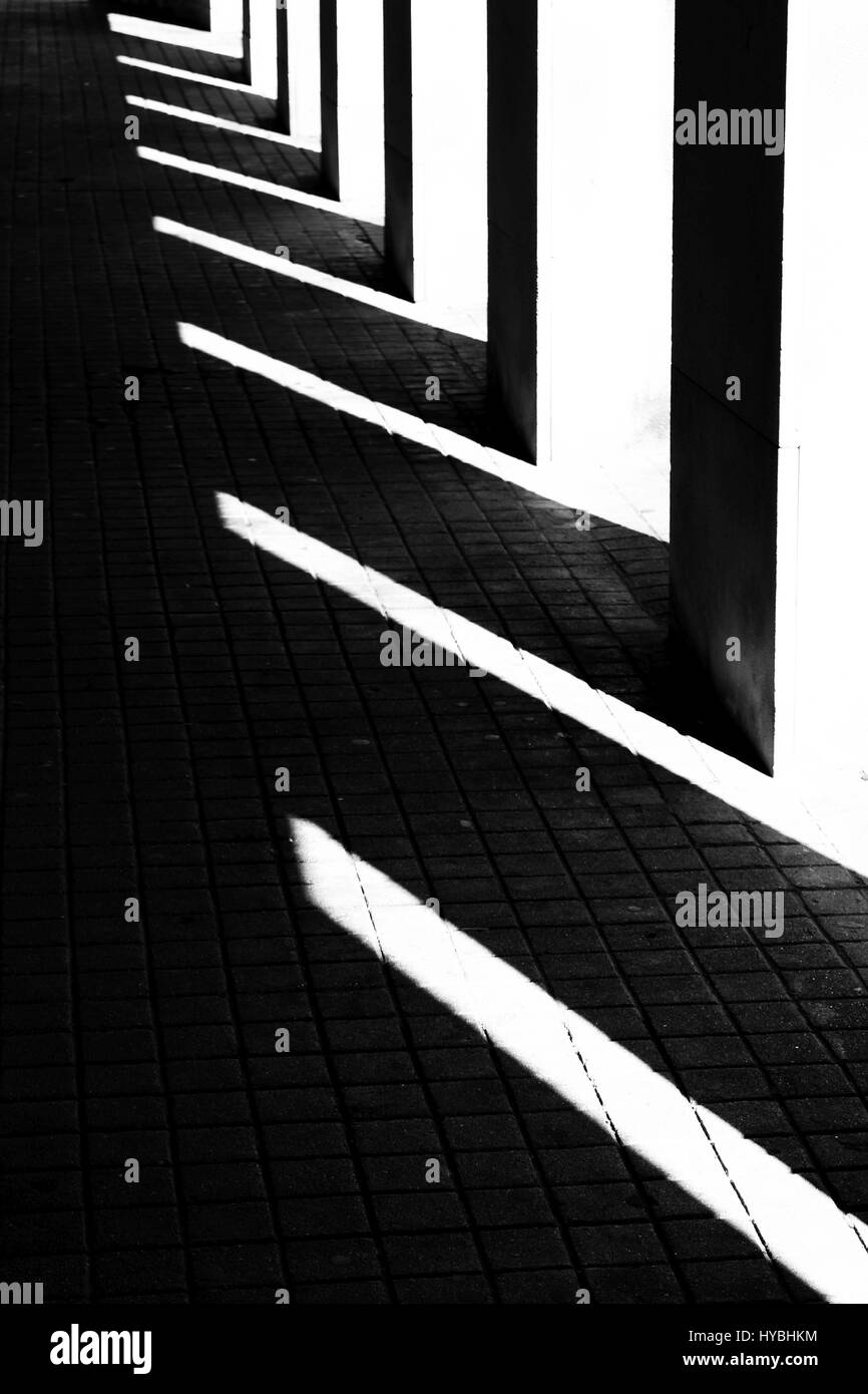 Un corredor de columnas de hormigón, de luces y sombras. Foto de stock