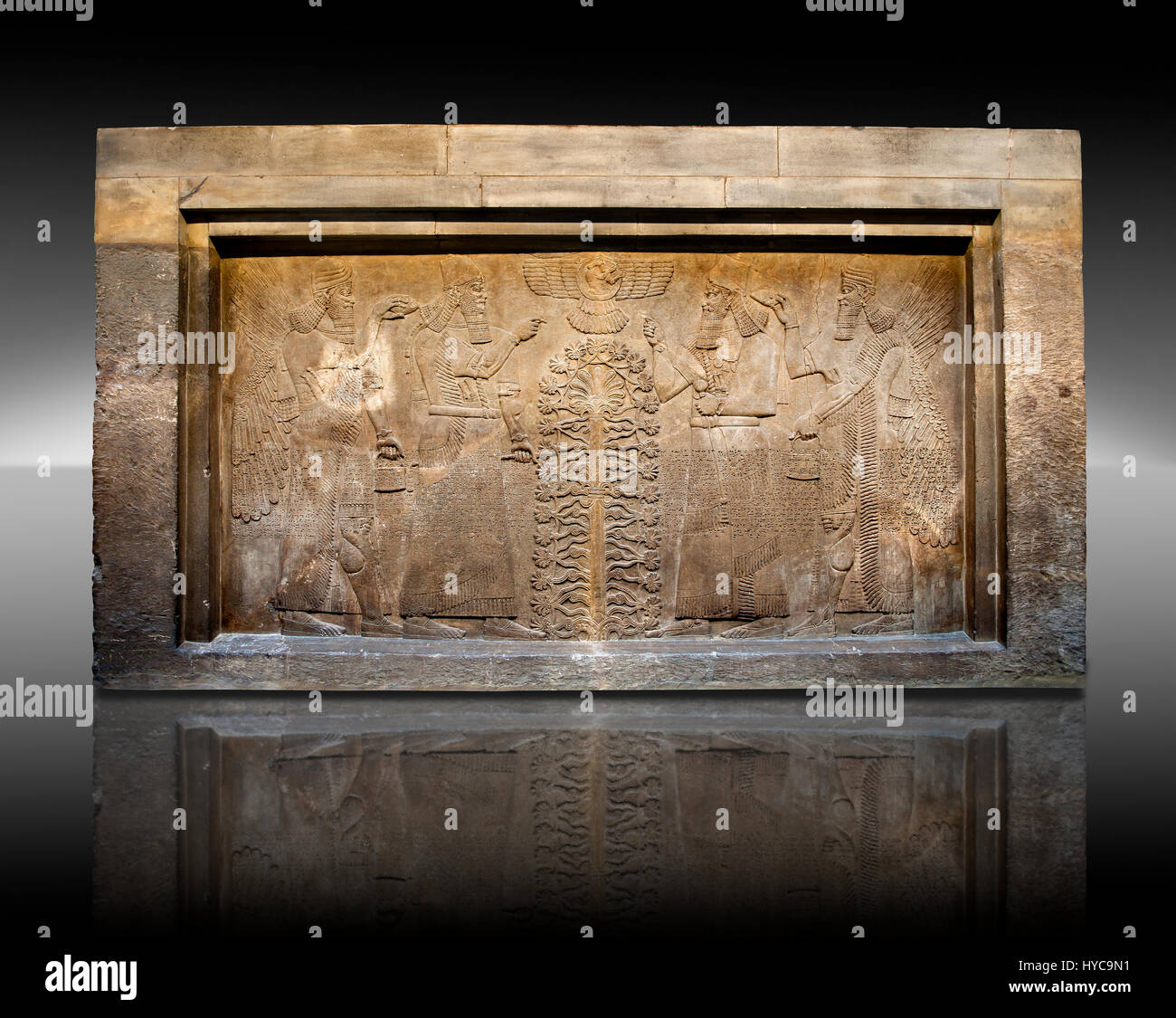 Panel de socorro de la escultura asiria del rey Ashurnasirpal II vestido con ropas rituales, es representado por dos veces en cada lado del árbol sagrado de central Foto de stock