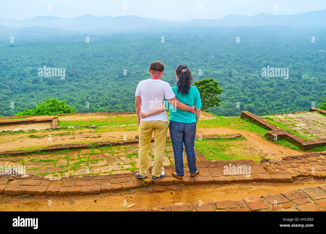 La pareja disfruta de la vista desde la cima de la Roca de Sigiriya, abrazarse entre las ruinas del antiguo palacio alto, Sri Lanka. Foto de stock