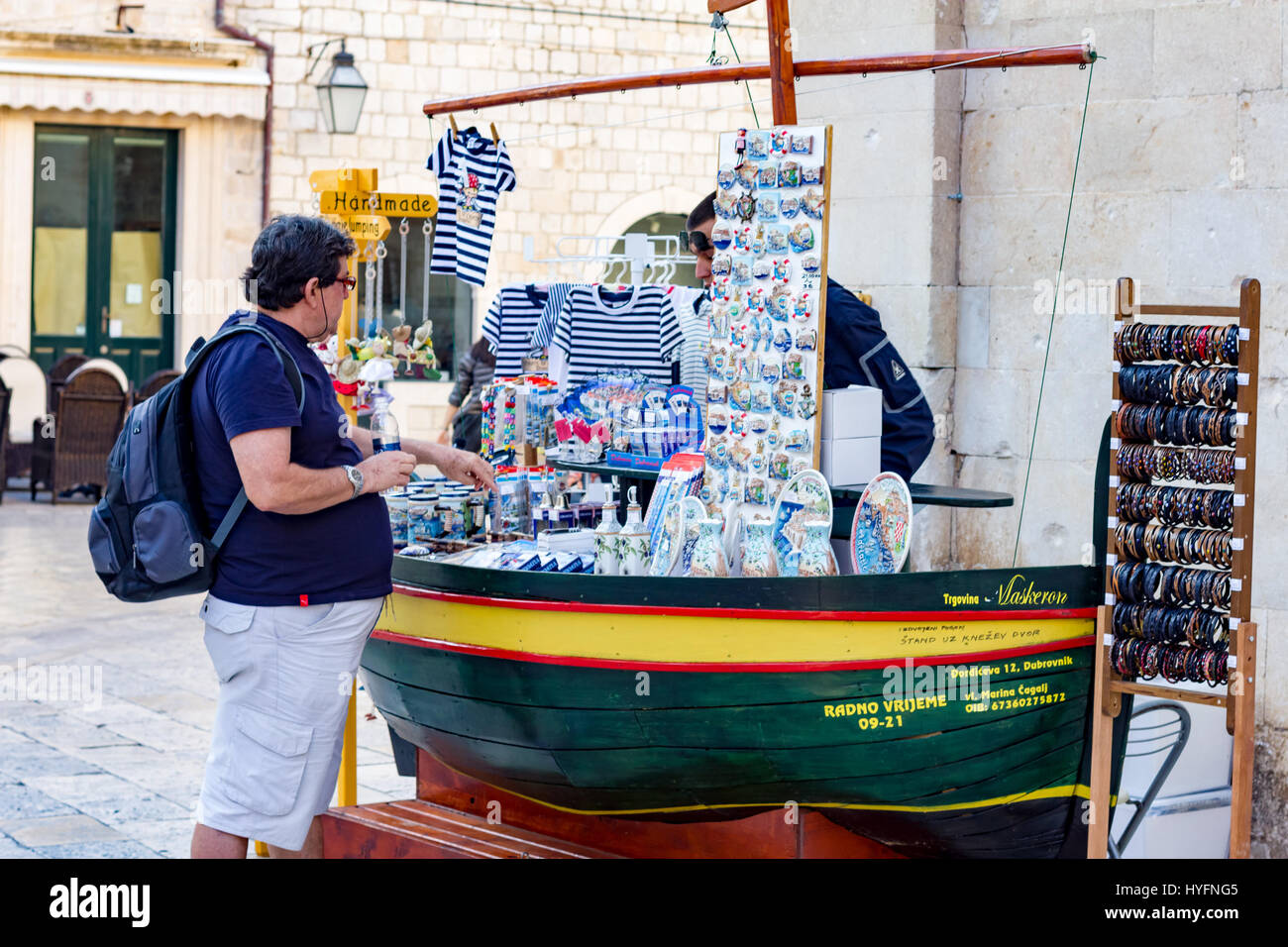Un comprador inspecciona un calado souvonir en Dubrovnik Foto de stock