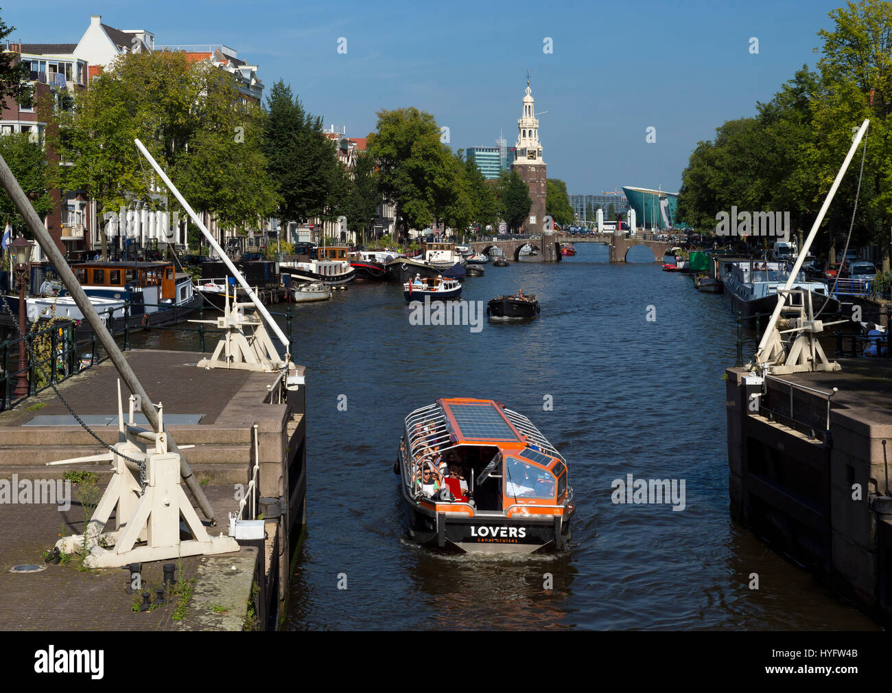 Los barcos turísticos en los canales de Amsterdam en sol de verano, Países Bajos, Europa Foto de stock