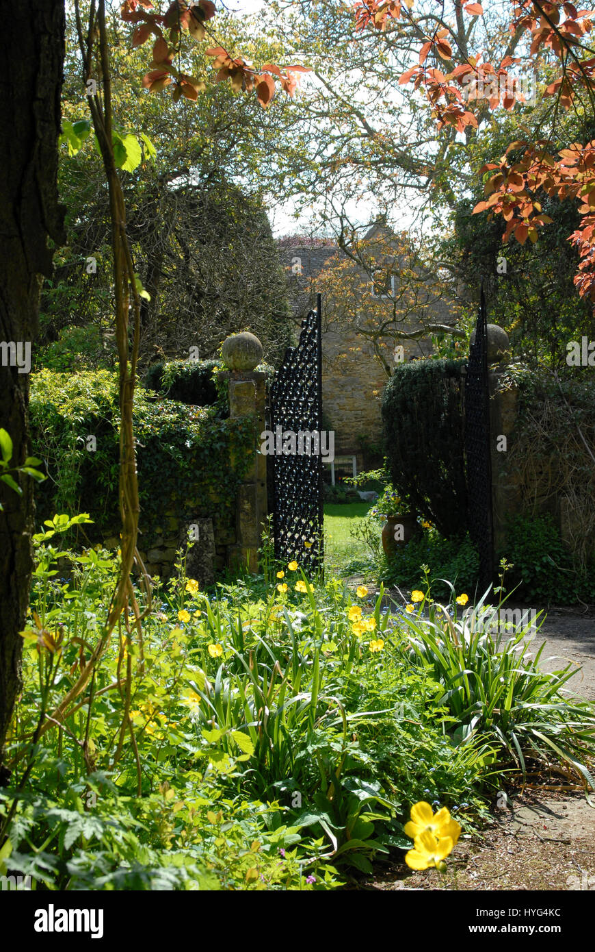 Escena en un jardín de la campiña inglesa, con paredes de piedra de Cotswold y plantación mixta Foto de stock