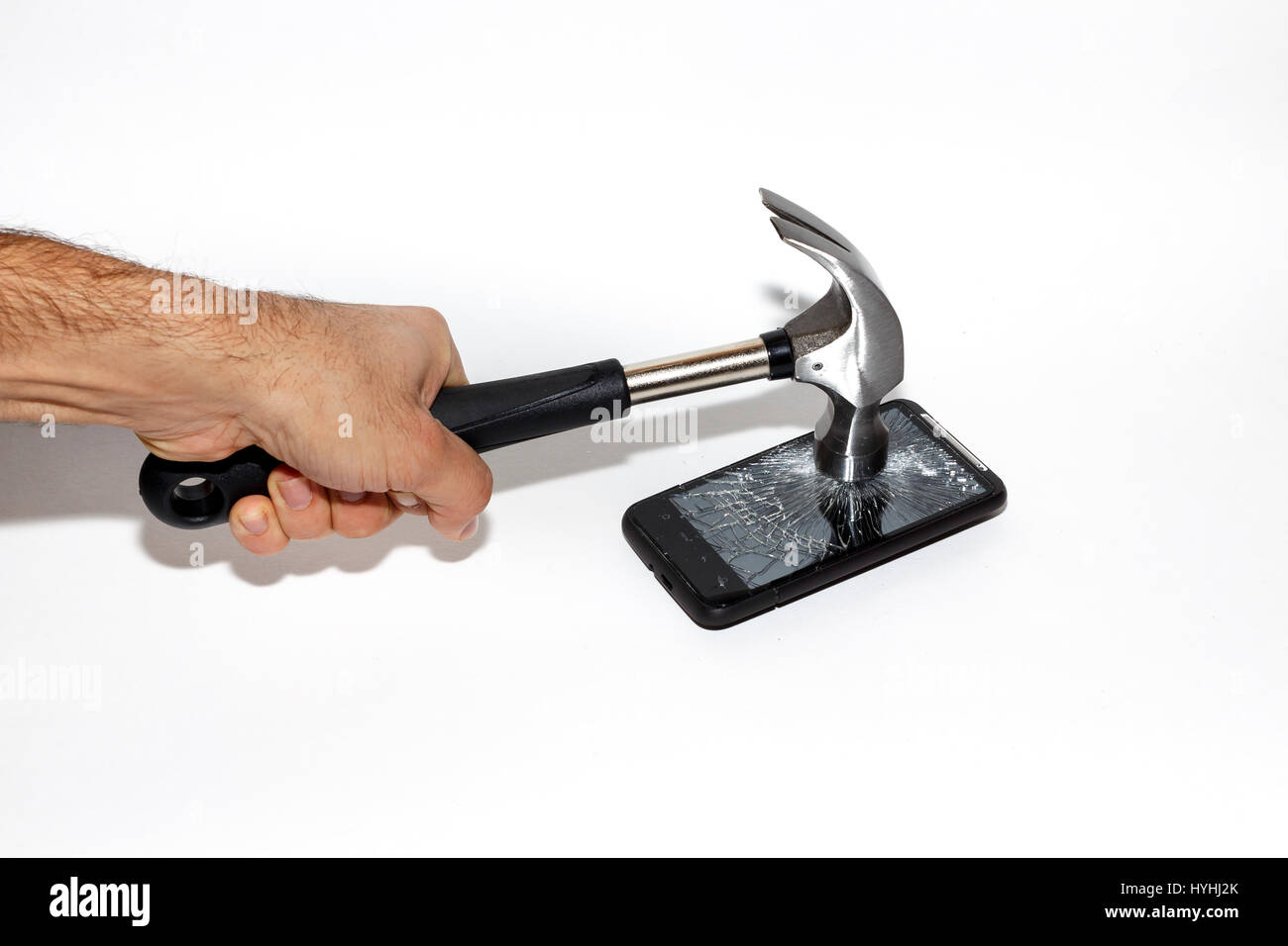 Un martillo golpeando un teléfono, destrozando su pantalla Fotografía de  stock - Alamy