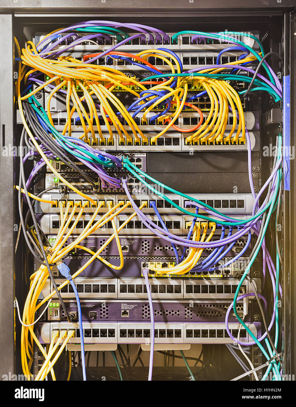 Armario rack abierto en el centro de datos moderno con paneles montados, switches, routers, servidores y otros equipos de telecomunicaciones conectados por cables de conexi n. Foto de stock