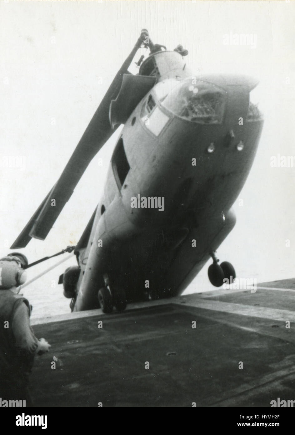 Un helicóptero CH-47 sur vietnamitas es empujada sobre el castillo de popa para dejar espacio para otros aviones que vuelan fuera de la muralla de la ciudad de Saigón con militares y sus familias en busca de refugio a bordo del USS HANCOCK durante ejercicios de evacuación. A bordo del USS Hancock, el 29 de abril de 1975. Foto de stock