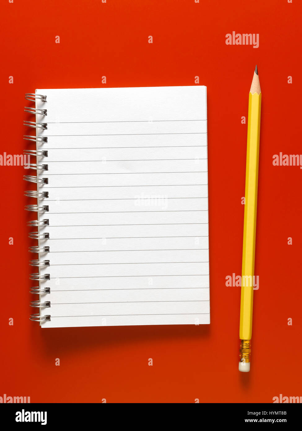 Lápiz amarillo aislado sobre un fondo rojo. Foto de stock
