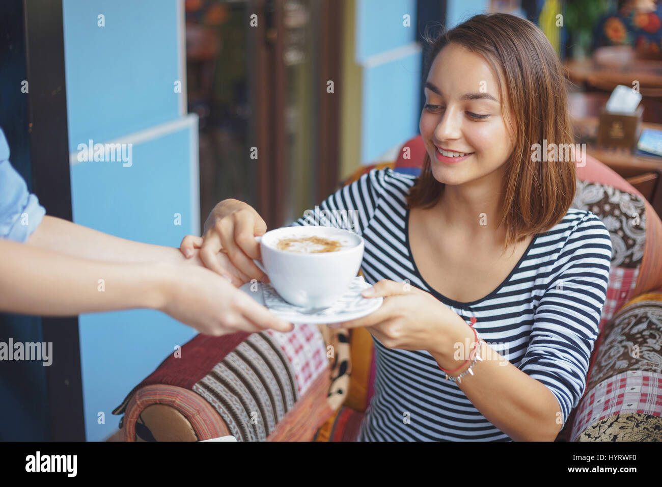 Mujer joven sentada en las zonas urbanas interiores cafe. Cafe de la vida de ciudad. Retrato de casual joven Foto de stock