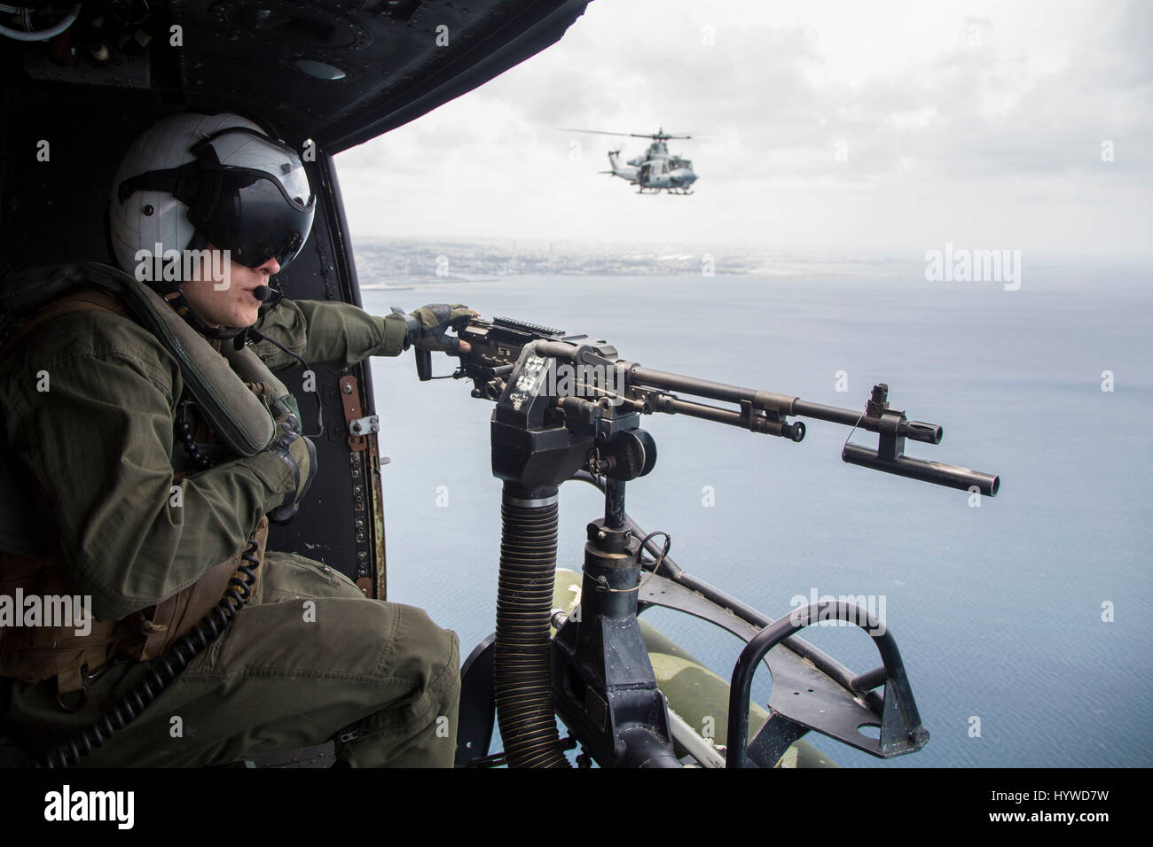 Owinawa, Japón. 26 abr, 2017. Cuerpo de Marina de los EE.UU. Jefe de la tripulación de Cpl. Justin Fry, mans la puerta pistola en un helicóptero UH-1Y Huey, mientras vuelan en una formación durante un ejercicio de ensayo de la Misión el 26 de abril de 2017 en Okinawa, Japón. Las fuerzas estadounidenses en la región de Asia han aumentado los ejercicios de combate como siguen aumentando las tensiones entre Estados Unidos y Corea del Norte. Crédito: Planetpix/Alamy Live News Foto de stock