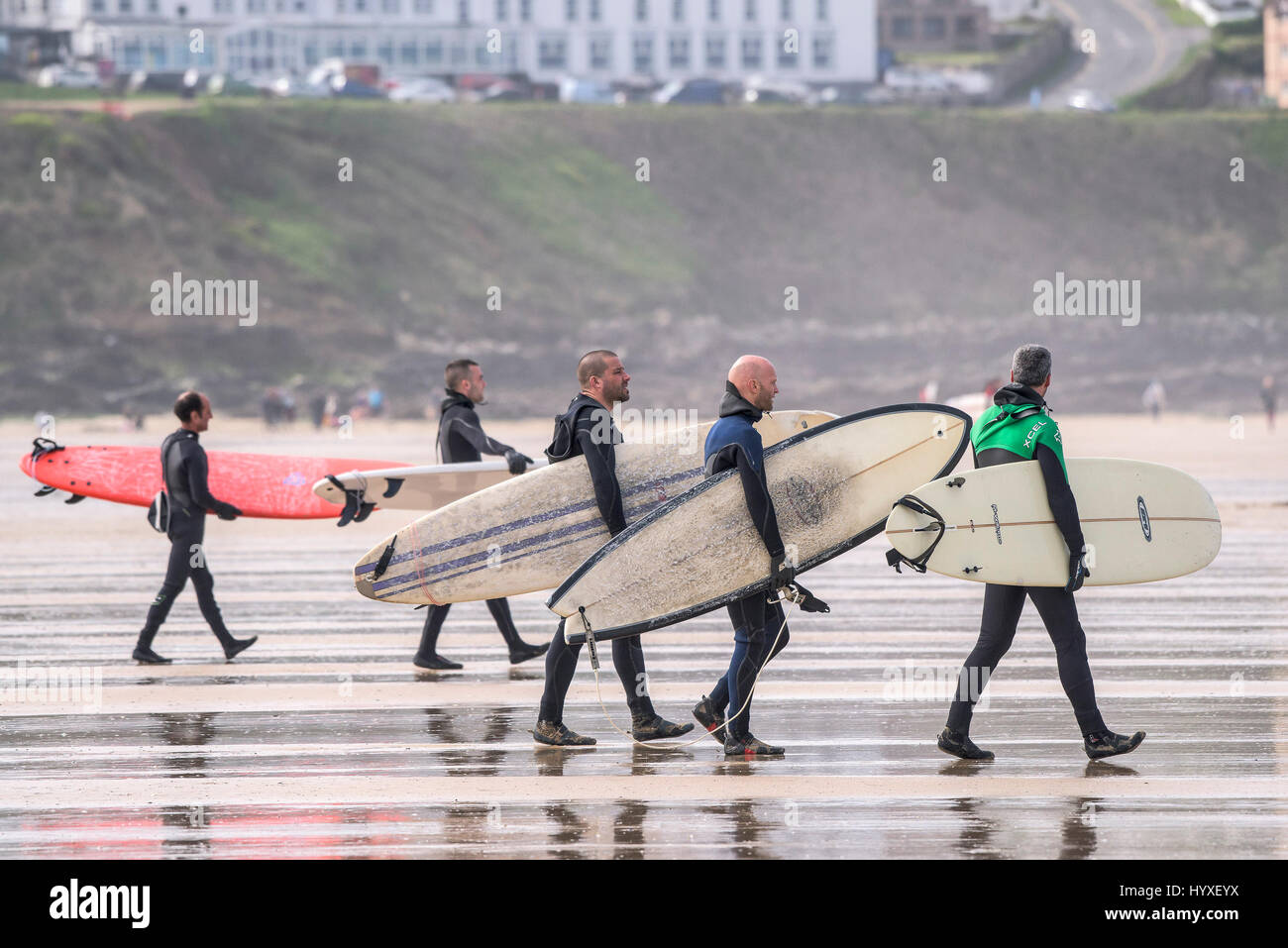 Los surfistas llevar tablas de surf surf UK Cornwall caminando sobre náutica de recreo en el estilo de vida de actividad de ocio amigos Foto de stock