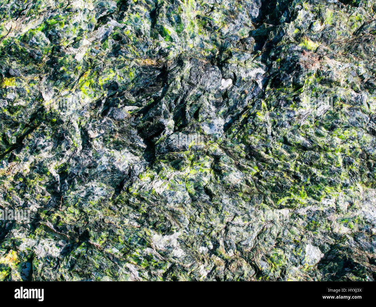 La hermosa textura de las piedras en bruto con el verde esmeralda de inclusiones y diversas fosas y tubérculos Foto de stock